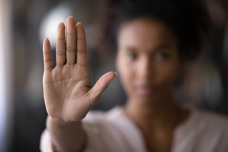 Frau mir ausgestreckter Hand, die Handfläche zeigt dabei nach vorne um ein "Stop" zu signalisieren.