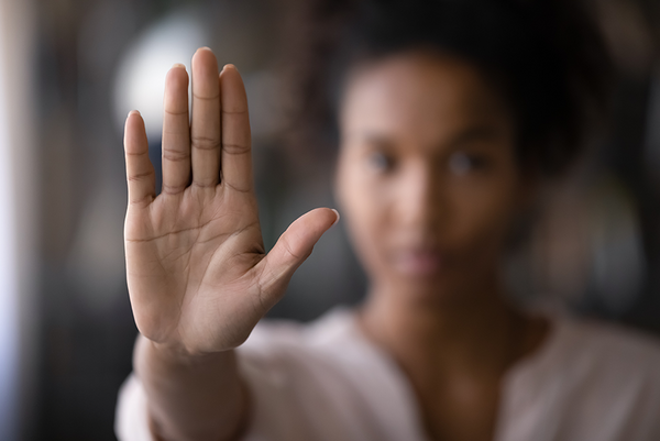 Frau mir ausgestreckter Hand, die Handfläche zeigt dabei nach vorne um ein "Stop" zu signalisieren.