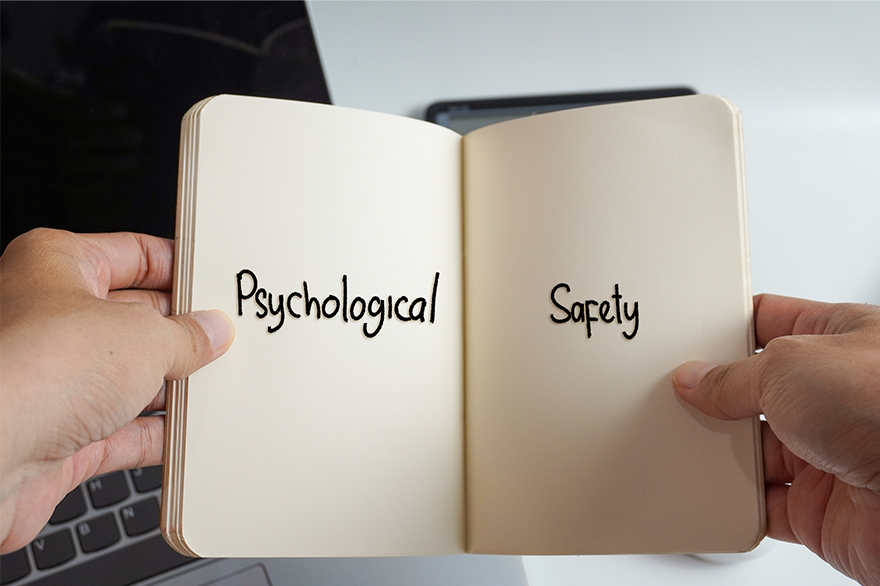 Hände, die ein Buch mit dem Wort Psychologische Sicherheit halten.