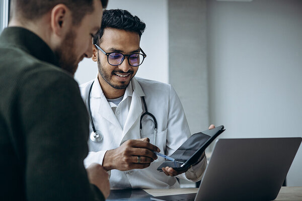 Ein männlicher Patient bei einem Kontrolltermin beim Arzt